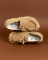 Pair of tan suede desert boots with tassel details and crepe soles, displayed from above.